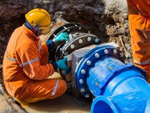 Man working on pipe in water