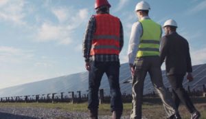 Three men in hard hats and high vis walking together